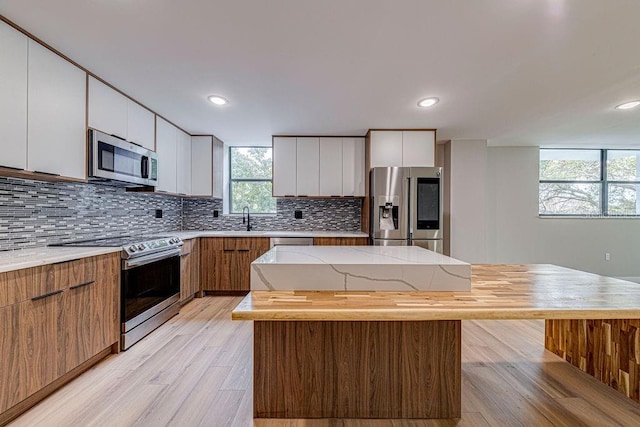 kitchen featuring stainless steel appliances, a center island, and white cabinets