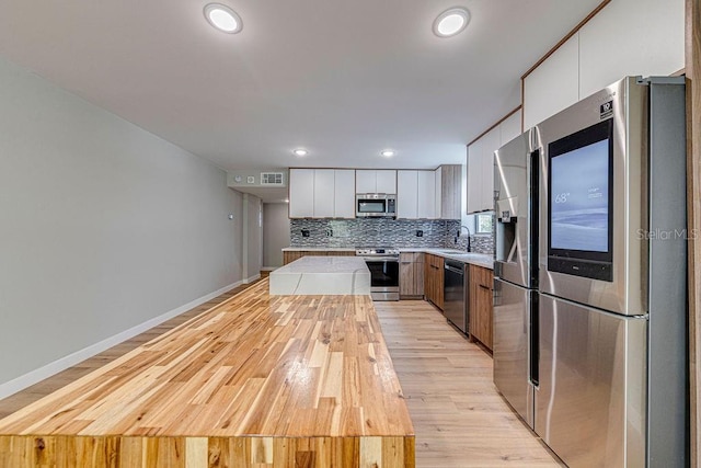 kitchen with visible vents, white cabinets, modern cabinets, appliances with stainless steel finishes, and light countertops