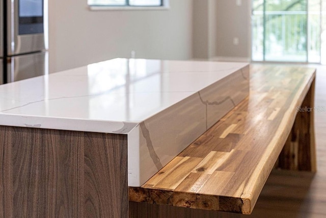 kitchen with smart refrigerator, light countertops, plenty of natural light, and wood finished floors