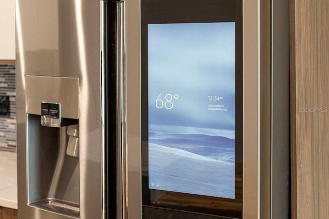 details featuring stainless steel refrigerator with ice dispenser