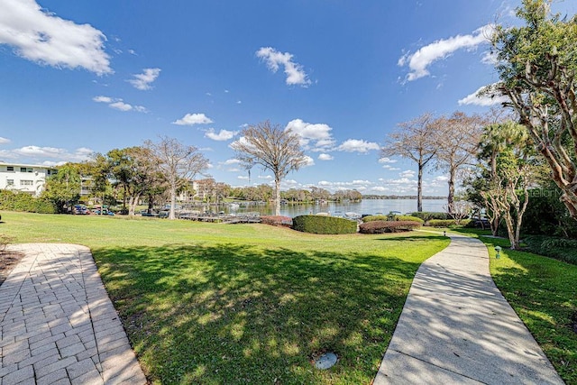 view of community featuring a lawn and a water view