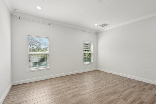 spare room featuring a textured ceiling, crown molding, and light hardwood / wood-style flooring