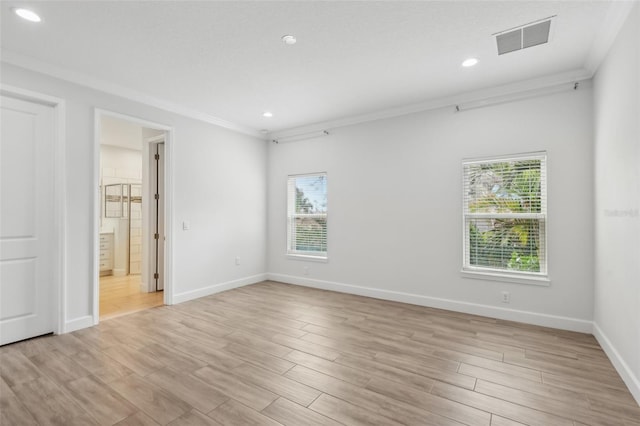 spare room featuring ornamental molding, plenty of natural light, and light wood-type flooring