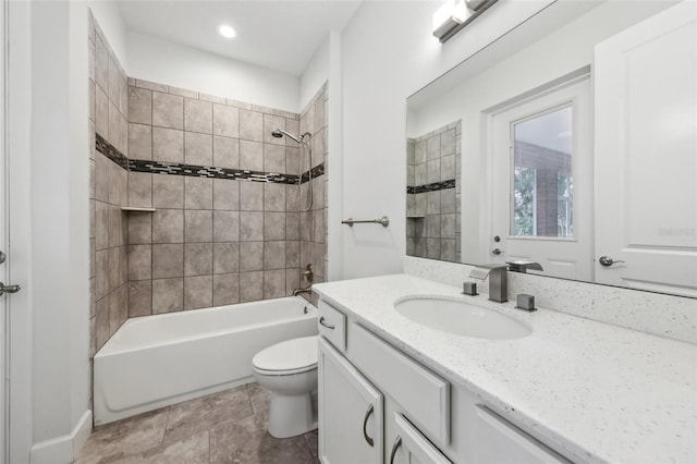 full bathroom with toilet, vanity, and tiled shower / bath combo