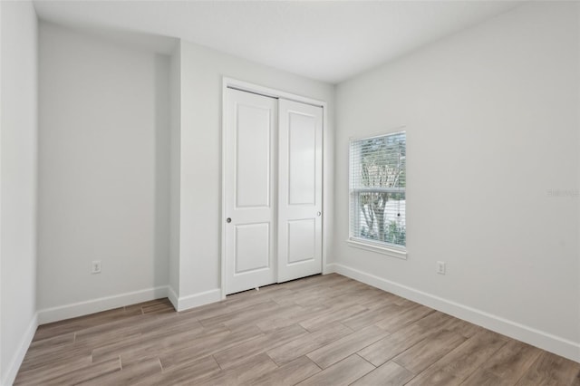 unfurnished bedroom featuring a closet and light hardwood / wood-style floors