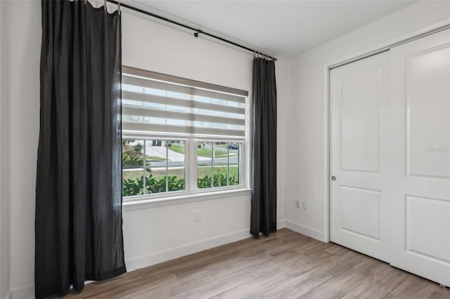 unfurnished bedroom with a closet and light hardwood / wood-style floors