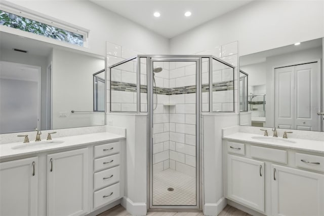 bathroom with a shower with shower door and vanity