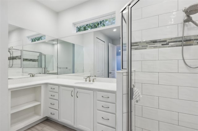 bathroom with vanity and a shower with door