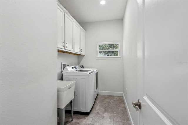 washroom featuring cabinets and washer and clothes dryer