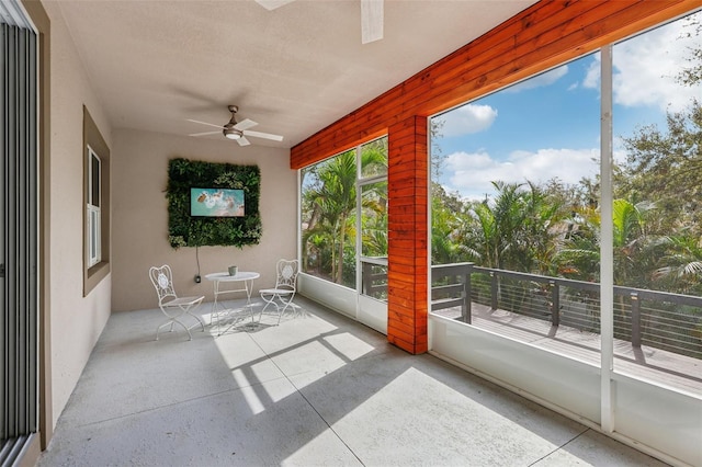 unfurnished sunroom featuring ceiling fan