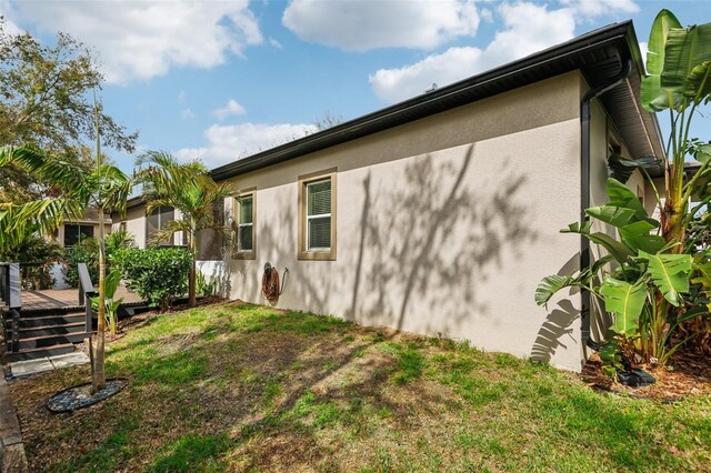 view of home's exterior with a yard and a wooden deck