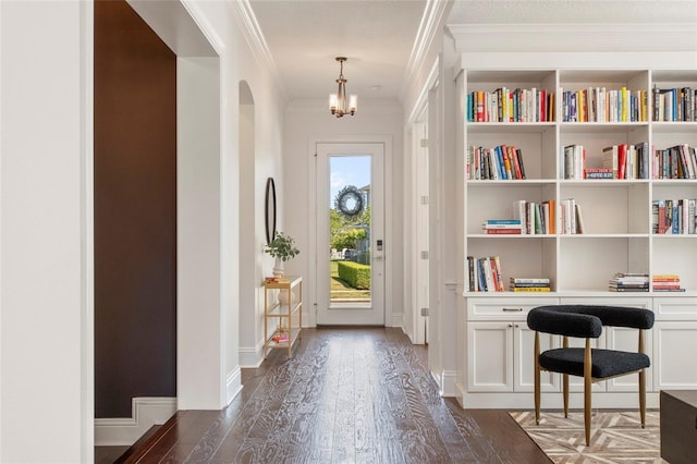 doorway featuring ornamental molding, a chandelier, and dark wood-style floors