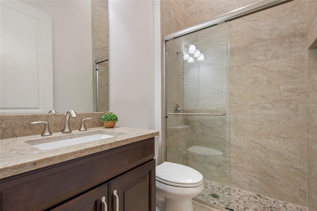 full bath with vanity, a stall shower, and toilet