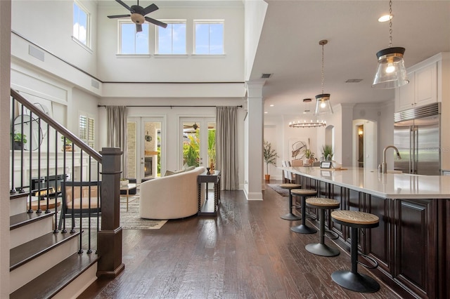 foyer entrance featuring dark wood-style flooring, baseboards, stairway, visible vents, and ceiling fan