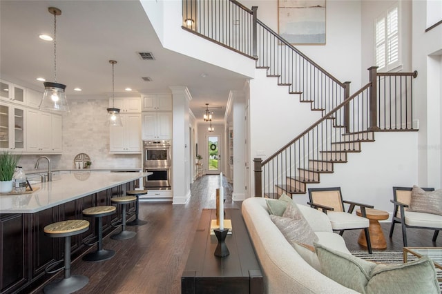 living area with recessed lighting, stairway, visible vents, and dark wood finished floors