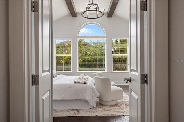 bedroom featuring a chandelier, baseboards, vaulted ceiling with beams, and wood finished floors