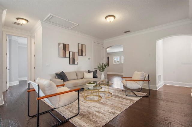living area with arched walkways, visible vents, and wood finished floors