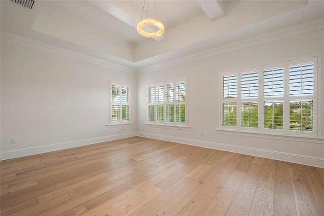unfurnished room featuring crown molding, visible vents, a raised ceiling, light wood finished floors, and baseboards