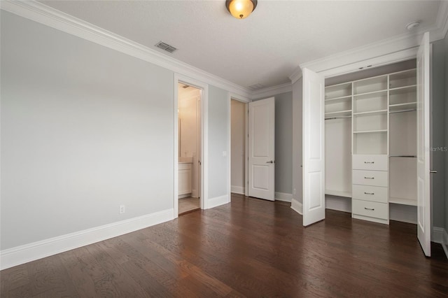 unfurnished bedroom with dark wood-style flooring, a closet, baseboards, and visible vents