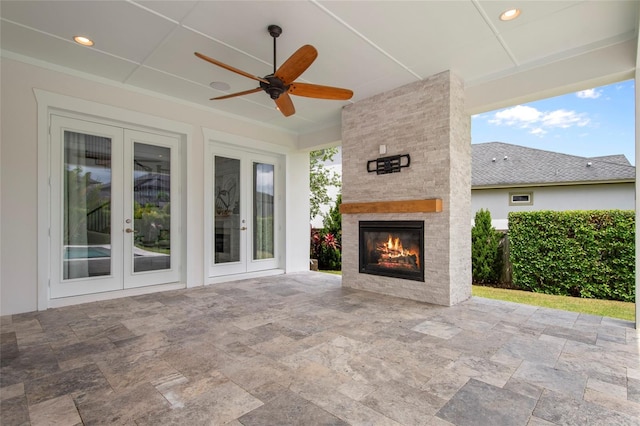 view of patio / terrace with french doors, ceiling fan, and a large fireplace