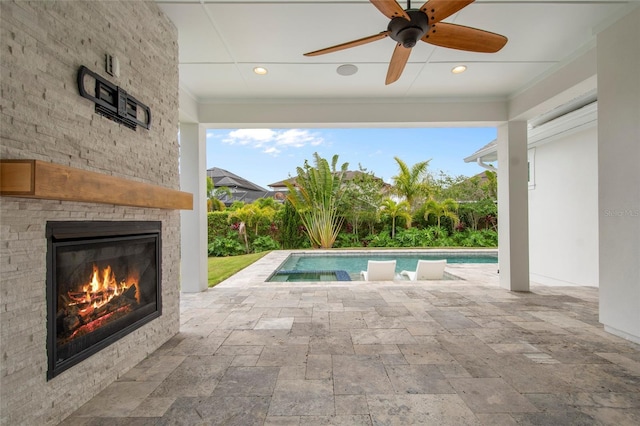 pool featuring a ceiling fan, a patio area, and a glass covered fireplace