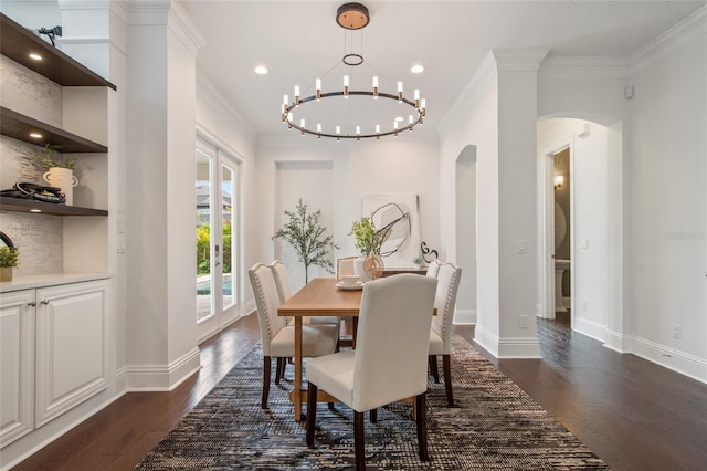 dining area with dark wood-type flooring, arched walkways, baseboards, and ornamental molding