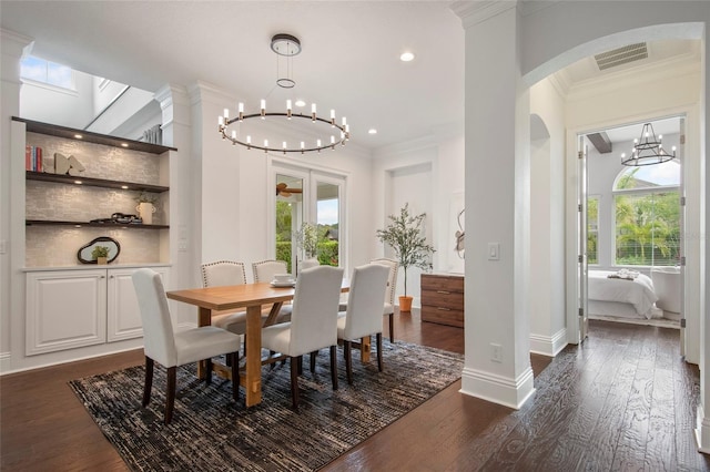 dining room featuring an inviting chandelier, dark wood finished floors, visible vents, and plenty of natural light