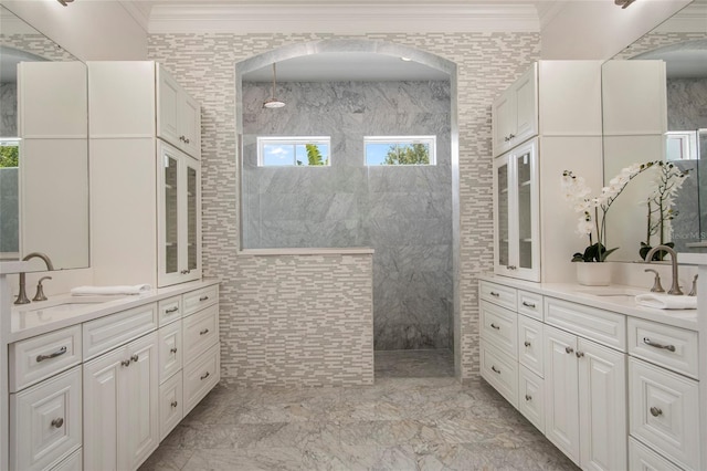 full bath featuring crown molding, a walk in shower, two vanities, marble finish floor, and a sink