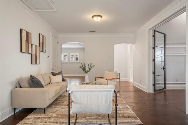 living room with arched walkways, visible vents, crown molding, and dark wood finished floors