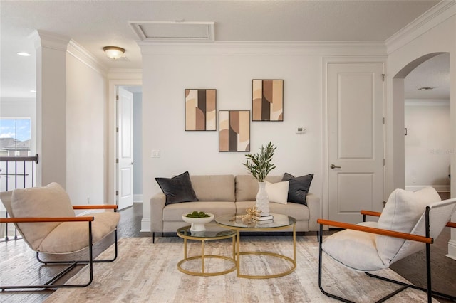 living area with arched walkways, baseboards, crown molding, and wood finished floors