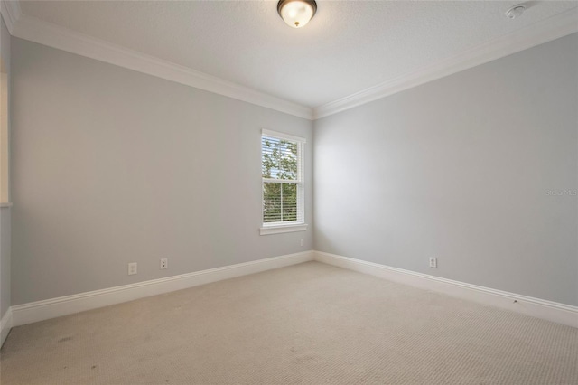 spare room featuring baseboards, light colored carpet, and ornamental molding