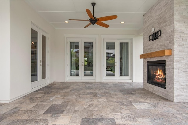 exterior space featuring a large fireplace, recessed lighting, french doors, ceiling fan, and stone finish flooring