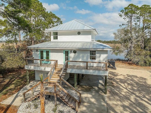 back of property featuring central air condition unit, a carport, french doors, and a garage