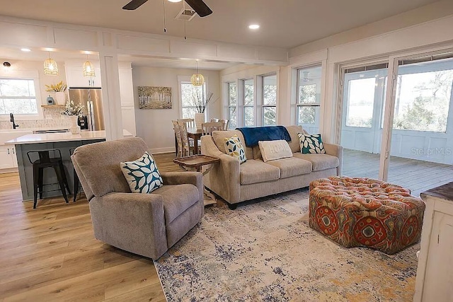 living room with light hardwood / wood-style floors and ceiling fan