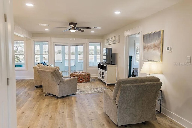 living room with light wood-type flooring and ceiling fan