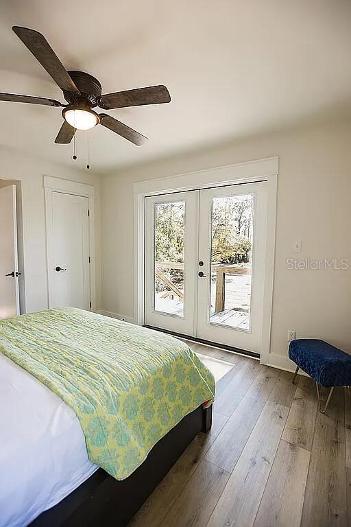 bedroom featuring ceiling fan, french doors, access to exterior, and hardwood / wood-style floors