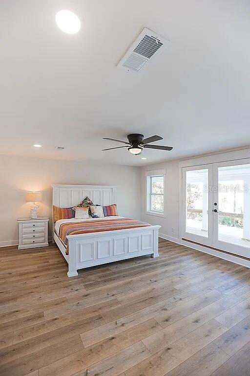 bedroom featuring ceiling fan, light hardwood / wood-style flooring, access to outside, and french doors