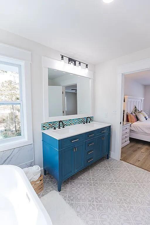 bathroom featuring tile patterned floors, a bathtub, and vanity