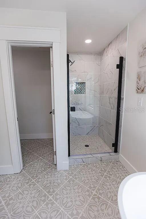 bathroom featuring tile patterned flooring and a shower with door