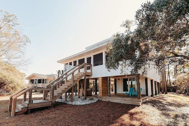 rear view of property with a sunroom and a wooden deck