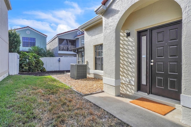 1008 Birkdale Trl, Winter Springs, FL 32708 - view of exterior entry with central air condition unit, fence, a lawn, and stucco siding