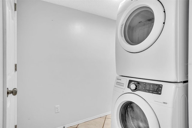 1008 Birkdale Trl, Winter Springs, FL 32708 - laundry area with light tile patterned floors, laundry area, baseboards, a textured ceiling, and stacked washing maching and dryer