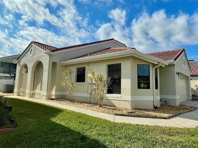 1008 Birkdale Trl, Winter Springs, FL 32708 - exterior space featuring a garage, a tile roof, a yard, central AC, and stucco siding