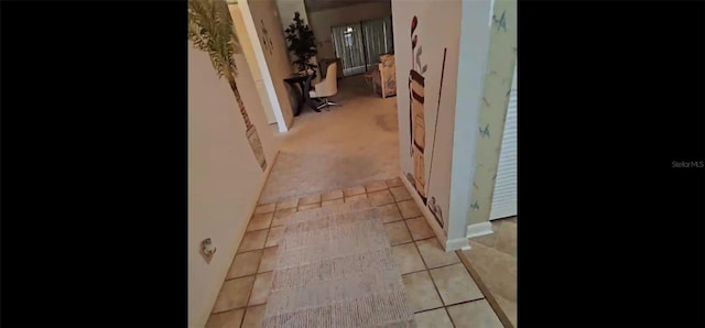 hallway featuring light carpet and light tile patterned flooring