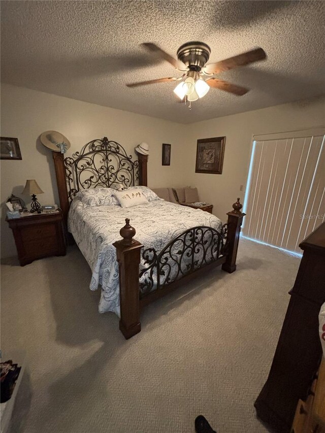 bedroom featuring carpet floors, ceiling fan, and a textured ceiling