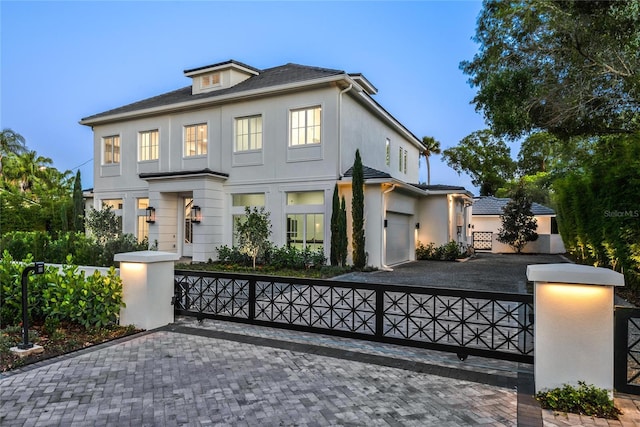 view of front of property featuring driveway, fence, and stucco siding