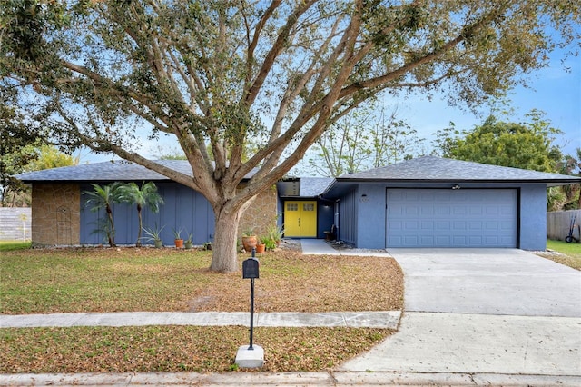 single story home featuring a front lawn and a garage