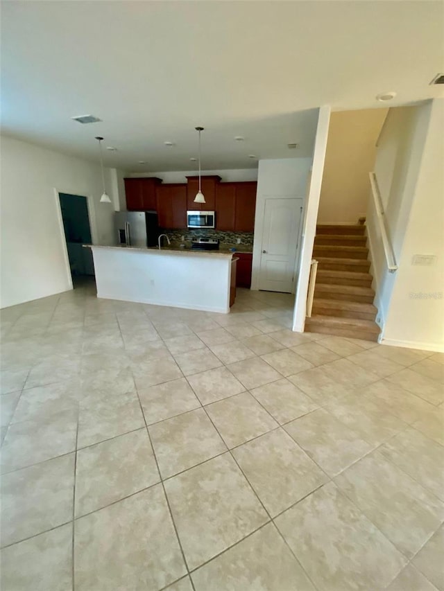 kitchen with appliances with stainless steel finishes, open floor plan, visible vents, and hanging light fixtures