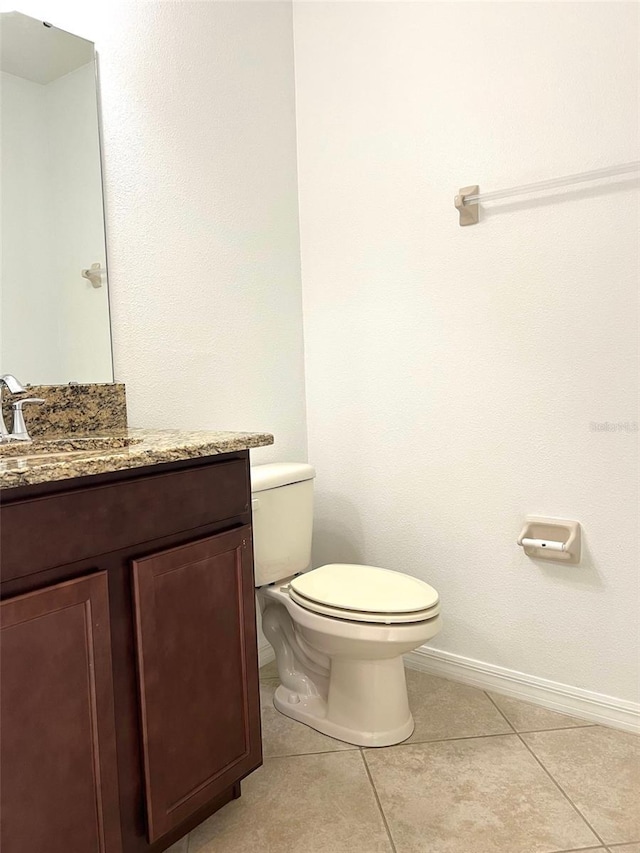 bathroom with vanity, tile patterned flooring, toilet, and baseboards