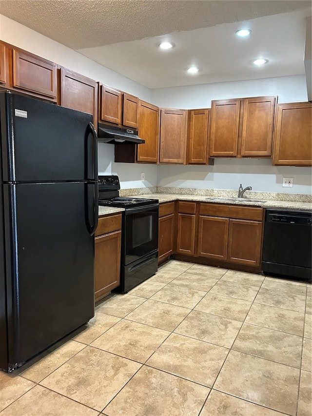 kitchen featuring light tile patterned floors, light countertops, a sink, under cabinet range hood, and black appliances